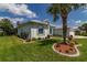 White house with palm tree, manicured lawn, and well-maintained landscaping at 2291 Nw 59Th Ter, Ocala, FL 34482