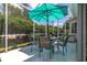 Relaxing screened patio with seating area, table, umbrella, and grill at 2291 Nw 59Th Ter, Ocala, FL 34482