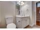 Guest bathroom with white vanity and toilet, near staircase at 4320 Se 106Th St, Belleview, FL 34420