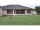 View of backyard with screened porch and grassy lawn at 4320 Se 106Th St, Belleview, FL 34420