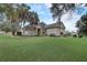 One-story house with large green lawn, palm trees, and a red front door at 4320 Se 106Th St, Belleview, FL 34420
