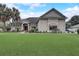 One-story house with large green lawn, palm trees, and a red front door at 4320 Se 106Th St, Belleview, FL 34420