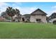 One-story house with large green lawn, palm trees, and a red front door at 4320 Se 106Th St, Belleview, FL 34420