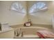 Relaxing corner bathtub with updated fixtures and unique window at 4320 Se 106Th St, Belleview, FL 34420