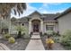 Tan house with red door, landscaping and walkway leading to the entrance at 4320 Se 106Th St, Belleview, FL 34420