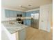 Modern kitchen with light blue cabinets, granite countertops, and stainless steel appliances at 535 W Silver Springs Pl, Ocala, FL 34475