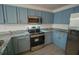 Modern kitchen with stainless steel appliances and light blue cabinets at 535 W Silver Springs Pl, Ocala, FL 34475
