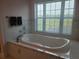 Relaxing bathroom with soaking tub and large window at 6895 Se 96Th Place Rd, Belleview, FL 34420