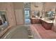 Primary bathroom with dual vanities, large mirrors, and a corner soaking tub at 1321 Sw 42Nd St, Ocala, FL 34471