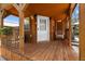 Inviting front porch with wooden flooring and a hanging chair at 14181 Se 211Th Court, Umatilla, FL 32784