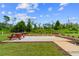 Landscaped pond with red picnic table nearby at 14181 Se 211Th Court, Umatilla, FL 32784