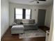 Living room with grey sectional sofa, ottoman, and wood-look floors at 4852 Sw 144Th St, Ocala, FL 34473
