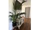 Hallway with a large plant, media console, and wood-look floors at 4852 Sw 144Th St, Ocala, FL 34473