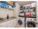 Bright laundry room with washer, dryer, and shelving at 10411 Sw 52Nd Ct, Ocala, FL 34476