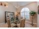 Elegant dining room features a glass table, stylish chairs, and an arched window at 10411 Sw 52Nd Ct, Ocala, FL 34476