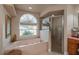 Relaxing bathroom with a soaking tub, shower, and large window at 10411 Sw 52Nd Ct, Ocala, FL 34476