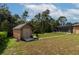 Tan shed with double doors and stone pathway in the backyard at 10411 Sw 52Nd Ct, Ocala, FL 34476