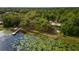 Aerial view of a lakefront home and dock, surrounded by trees at 22645 Ne 105Th Avenue Rd, Fort Mc Coy, FL 32134