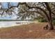 Serene lakeside setting with a dock and bench, under a large oak tree at 22645 Ne 105Th Avenue Rd, Fort Mc Coy, FL 32134