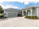Green house exterior with a large driveway and garage at 3051 Sw 41St Pl, Ocala, FL 34474