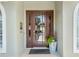 Modern brown front door with glass panels and potted plants at 3051 Sw 41St Pl, Ocala, FL 34474