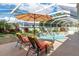 Two lounge chairs under an umbrella by the pool at 3051 Sw 41St Pl, Ocala, FL 34474