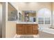 Bathroom with double vanity and large mirror, adjacent to soaking tub at 3051 Sw 41St Pl, Ocala, FL 34474