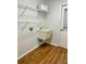 Laundry room with utility sink, shelving, and wood-look flooring at 10787 Sw 53Rd Cir, Ocala, FL 34476