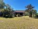 House's back exterior with a large backyard and tropical plants at 10787 Sw 53Rd Cir, Ocala, FL 34476
