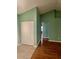 Hallway with green walls and wood flooring, leading to other rooms at 10787 Sw 53Rd Cir, Ocala, FL 34476