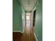 Hallway with light green walls and wood flooring at 10787 Sw 53Rd Cir, Ocala, FL 34476