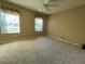 Tan bedroom with carpet, ceiling fan and window at 10787 Sw 53Rd Cir, Ocala, FL 34476