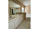 Bathroom with double vanity, large mirror, and a garden tub at 10787 Sw 53Rd Cir, Ocala, FL 34476