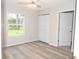 Spacious bedroom with large window, wood-look flooring, and double closet at 3011 Nw 3Rd Ter, Ocala, FL 34475