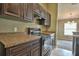 Modern kitchen features dark wood cabinets, granite countertops, and a view into the dining area at 12472 Sw 85Th Pl, Dunnellon, FL 34432
