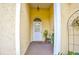 Front entry with a white door, terracotta tile flooring and potted plants at 567 Silver Course Run, Ocala, FL 34472