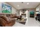 Bright living room with tile floors, large sectional sofa, and aquarium at 567 Silver Course Run, Ocala, FL 34472