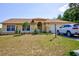 Single-story house with a yellow exterior, a car in the driveway, and a well-maintained lawn at 567 Silver Course Run, Ocala, FL 34472