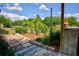 Landscaped backyard with a brick pathway, lush greenery, and a wooden pergola at 567 Silver Course Run, Ocala, FL 34472