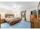 Spacious Primary bedroom with wood furniture and blue carpet at 7994 Se 174Th Belhaven Loop, The Villages, FL 32162