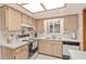 Bright kitchen features wood cabinets, white appliances, and a double sink at 10881 Sw 79Th Ter, Ocala, FL 34476