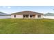 Rear view of a one-story house with a covered patio and a large yard at 3235 Se 43Rd Ave, Ocala, FL 34480