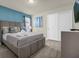 Bedroom with a gray upholstered bed, teal accent wall, and double doors at 3004 Mahalo Dr, Davenport, FL 33897