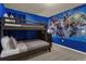 Bunk bed in a ' bedroom featuring a Marvel Comics wall mural at 3004 Mahalo Dr, Davenport, FL 33897