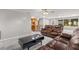 Living room showcasing a modern aesthetic, brown leather furniture, and open kitchen access at 11782 Sw 140Th St, Dunnellon, FL 34432