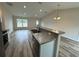 Open kitchen with island, stainless steel appliances, and wood-look floors at 233 Locust Ln, Ocala, FL 34472