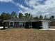 Newly built home with grey exterior, landscaping and driveway at 235 Locust Ln, Ocala, FL 34472