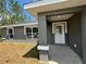 Front entrance with covered porch and white door at 235 Locust Ln, Ocala, FL 34472