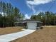 Newly constructed home with gray exterior, white garage door, and a concrete driveway at 235 Locust Ln, Ocala, FL 34472