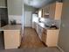 Long galley kitchen with light wood cabinets and flooring at 7946 Juniper Rd, Ocala, FL 34480